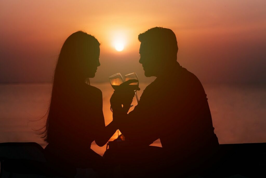 couple enjoying wine during sunset